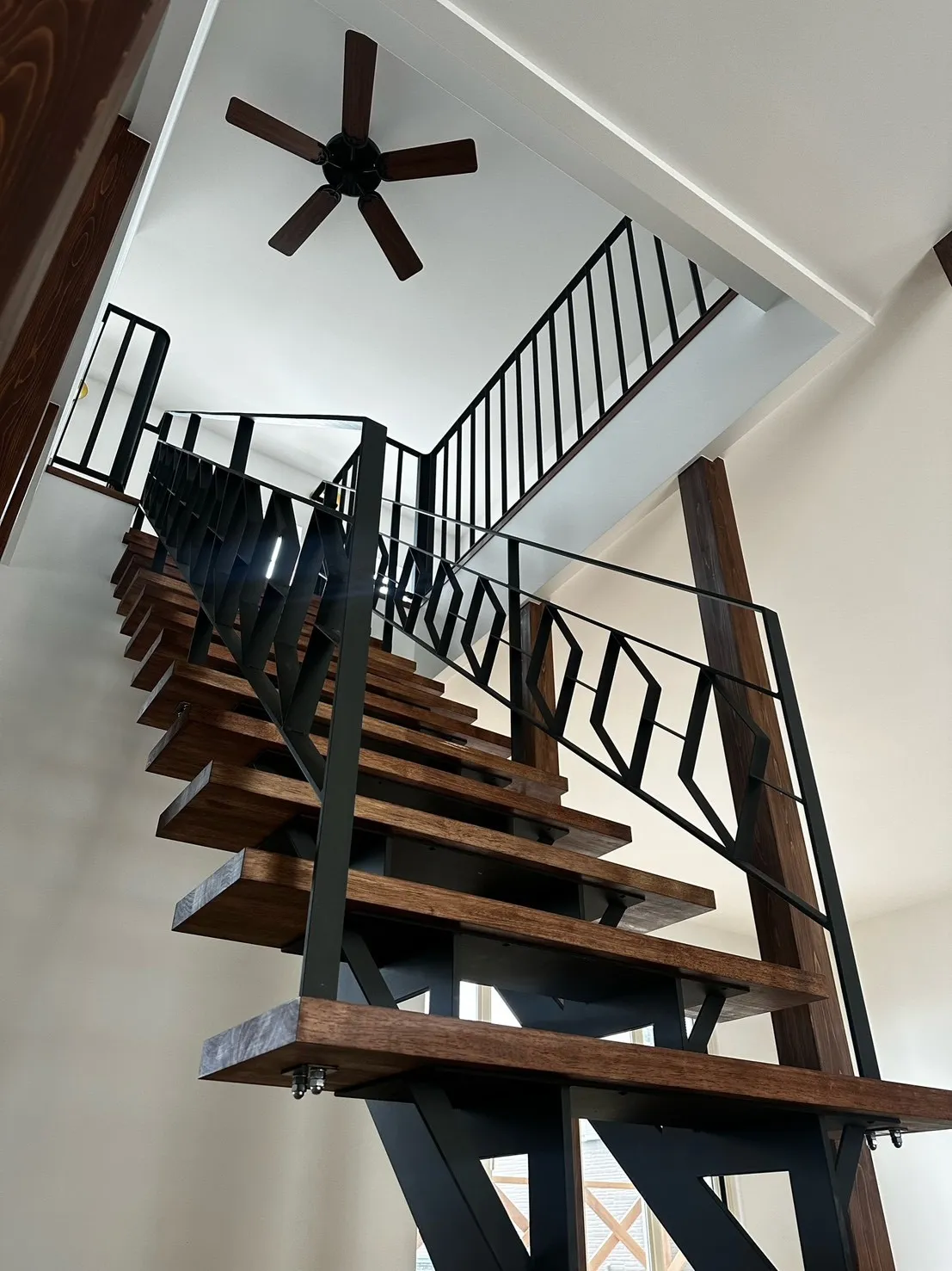 吹き抜けに映える鉄骨階段とアイアン手すり