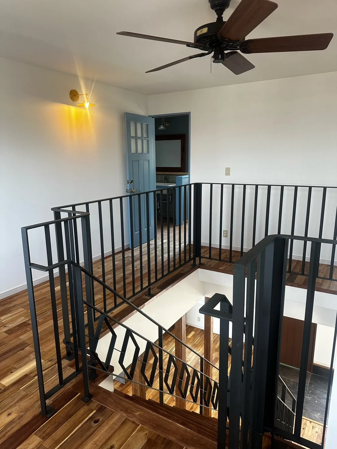 吹き抜けに映える鉄骨階段とアイアン手すり